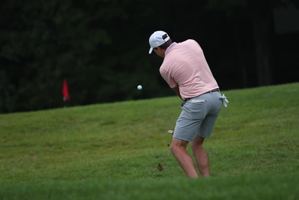 A golfer hits a lob wedge towards the hole