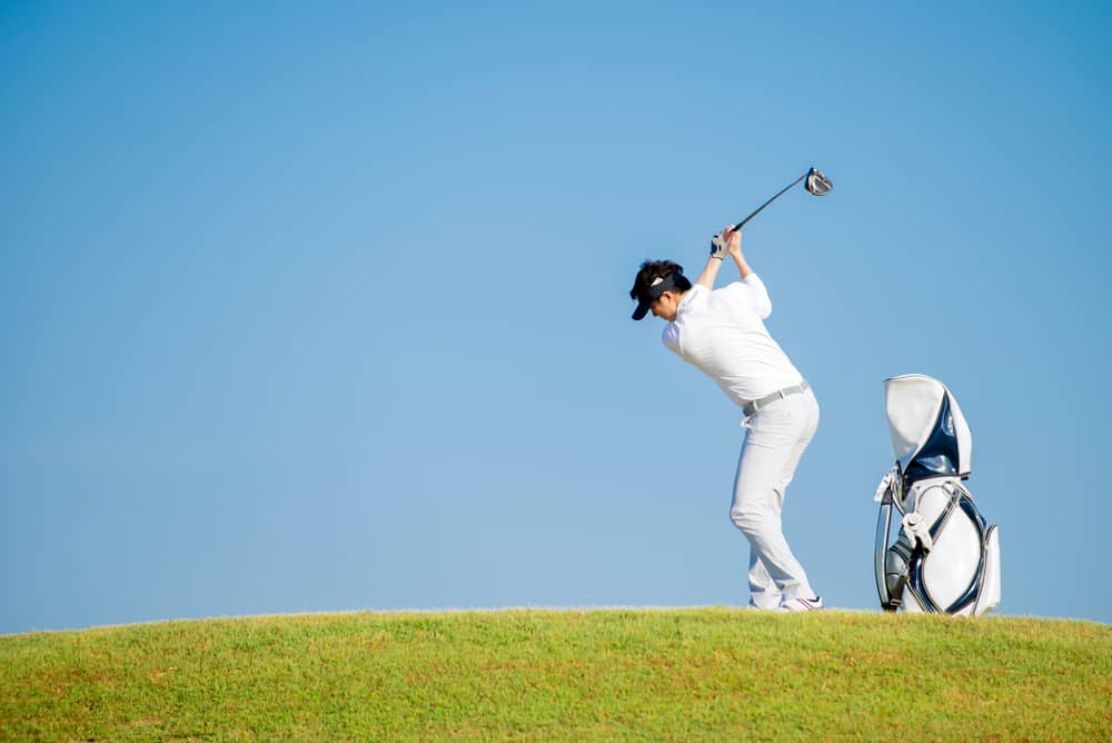 Asian man golfer standing on slope