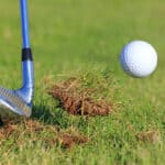 Big Divot While Chipping Golf Ball Out Of The Rough Grass