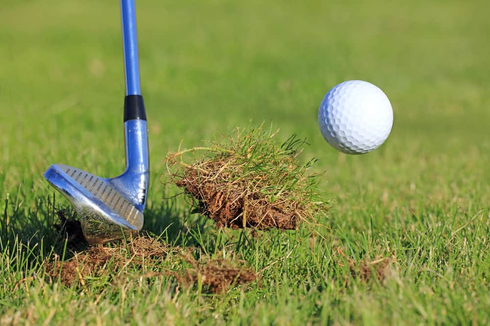 Big Divot While Chipping Golf Ball Out Of The Rough Grass