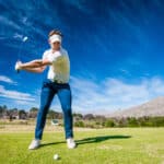 Close up image of a male golfer playing a shot on the fairway on a golf course