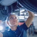 Female Mechanic Working Under Vehicle