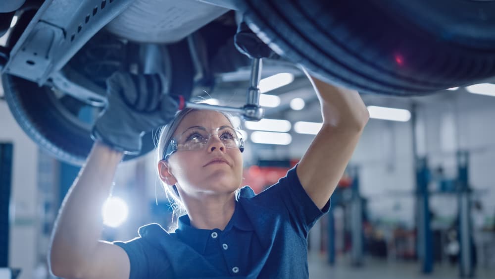 Female Mechanic Working Under Vehicle