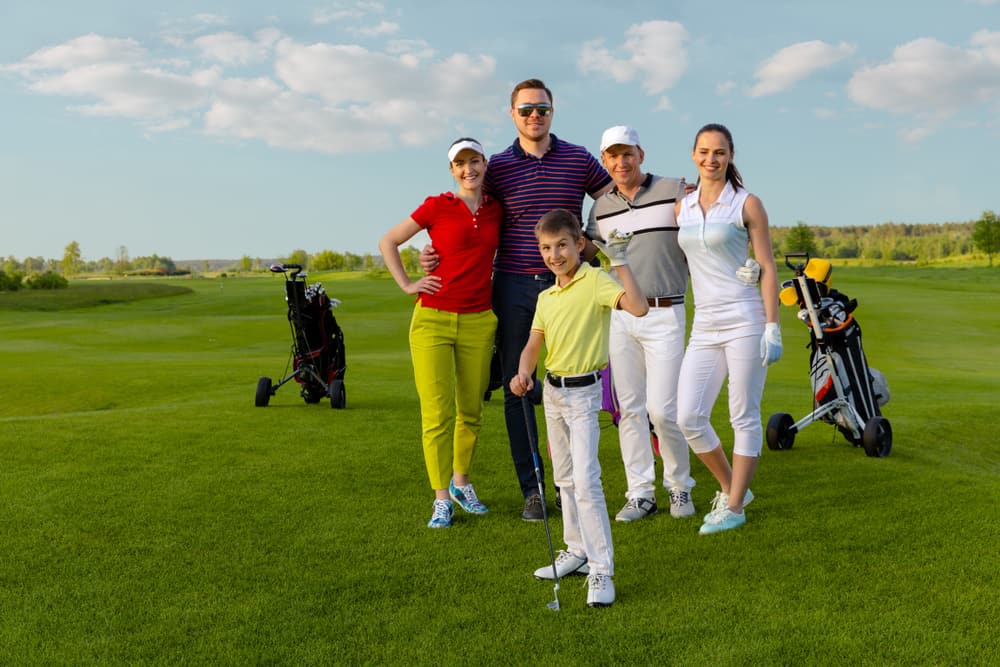 Four adult friends golfers and kid are happy to finish their golf game