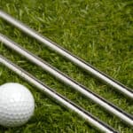 Golf ball and golf clubs with steel shaft on grass