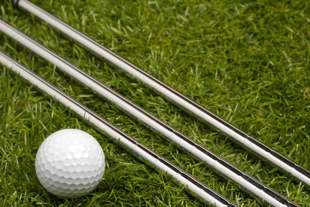 Golf ball and golf clubs with steel shaft on grass