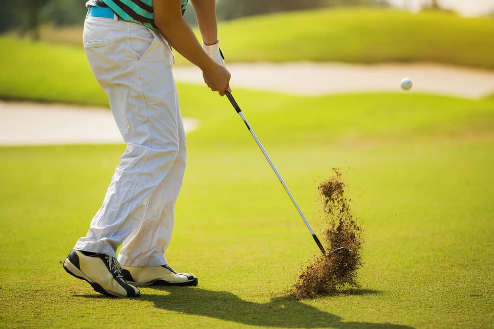 Golfer hitting ball with force