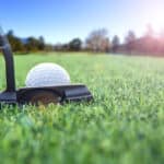 Golfer long putting golf ball in to the hole