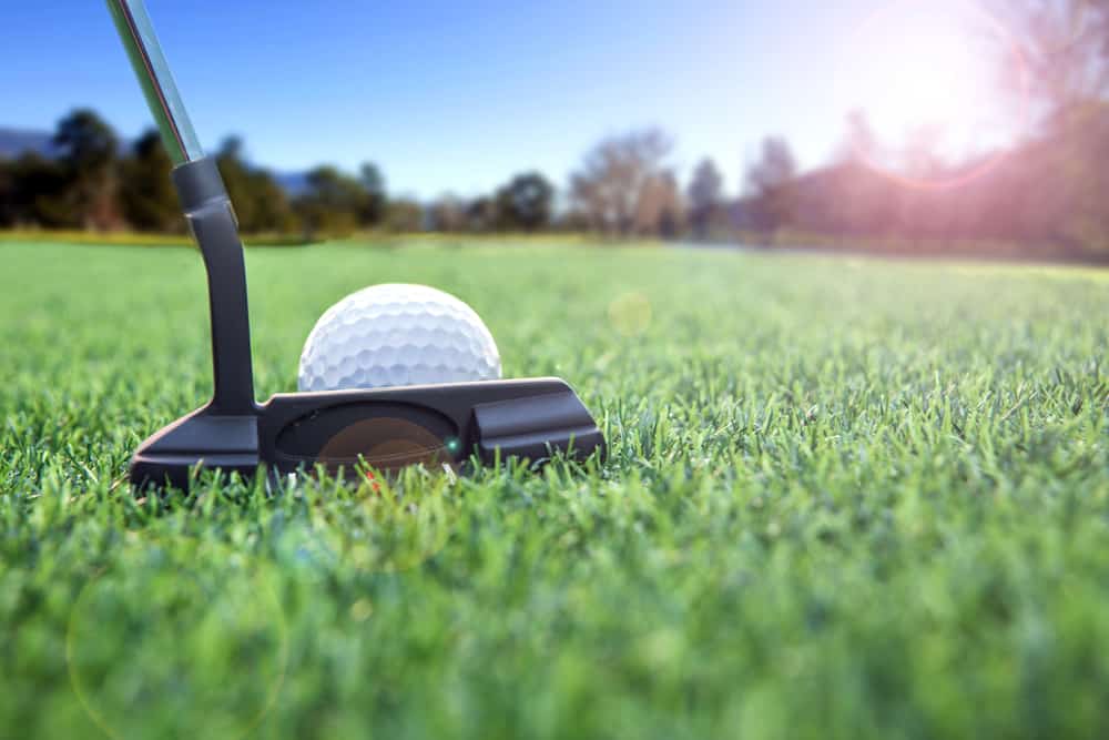 Golfer long putting golf ball in to the hole