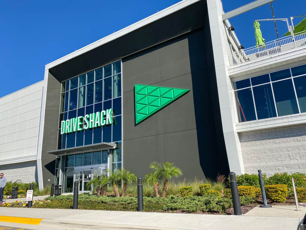 The building exterior of a Drive Shack where people can play interactive golf games, eat, and drink with friends