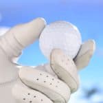 hand in glove holding golf ball
