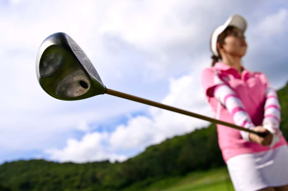 young girl preparation to drive golf