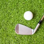 Top view golf club and golf ball on green grass background