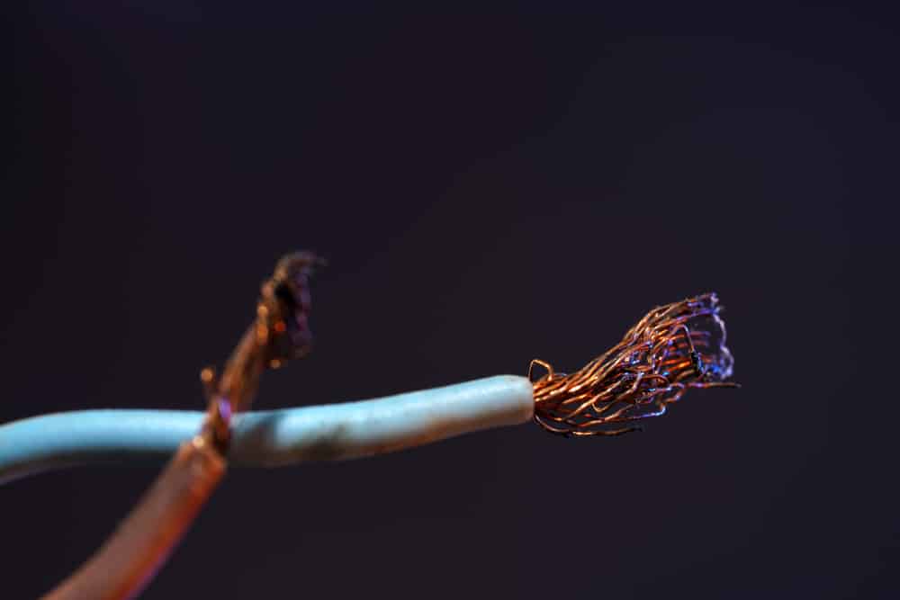 A closeup shot of white wires with frayed copper edges