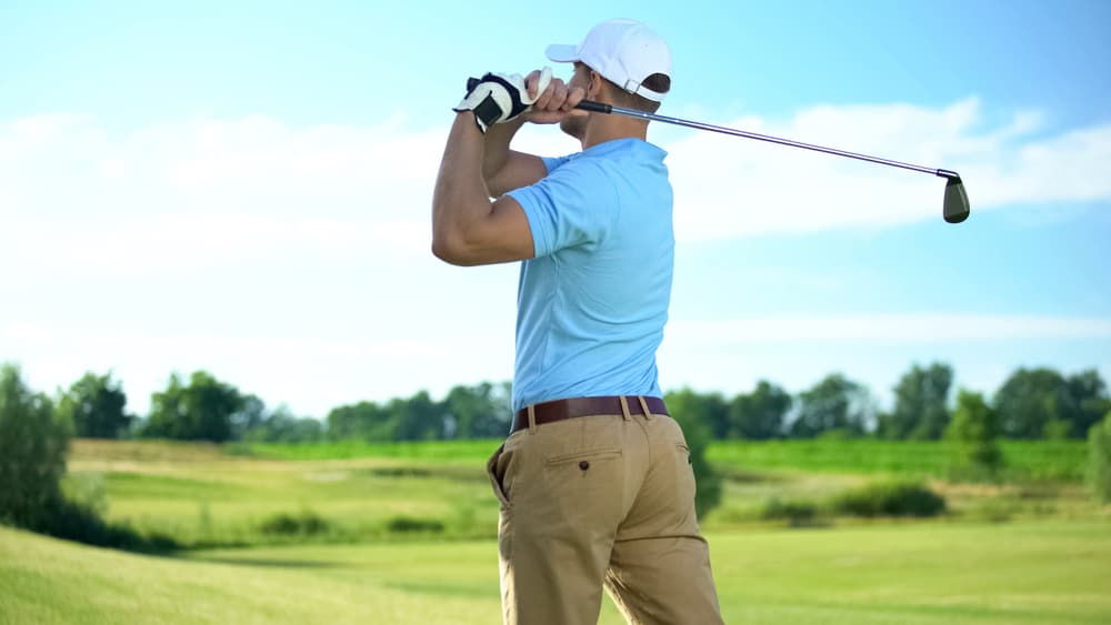 Experienced golf player hitting ball in draw position