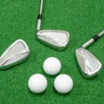 Golf clubs and golf balls placed on artificial grass