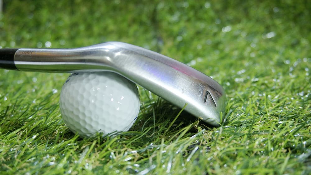 Golf iron and ball on green grass - iron 7