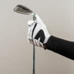 Golfer Wearing Golf Glove holding iron wage, golf equipment