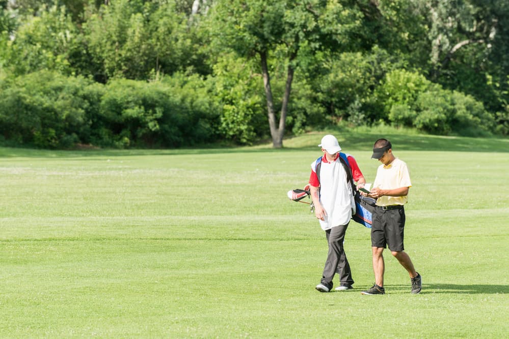 Golfer and caddy on a golf course