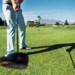 Golfer hitting driver club on course