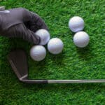 Hand hold golf ball on grass