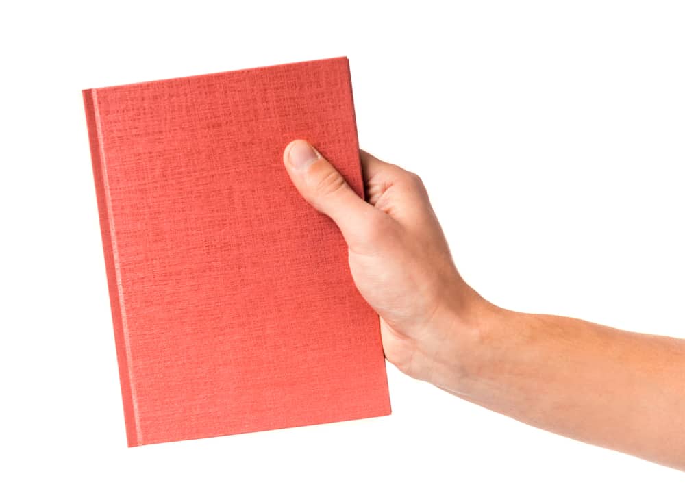 Male hand holding a book