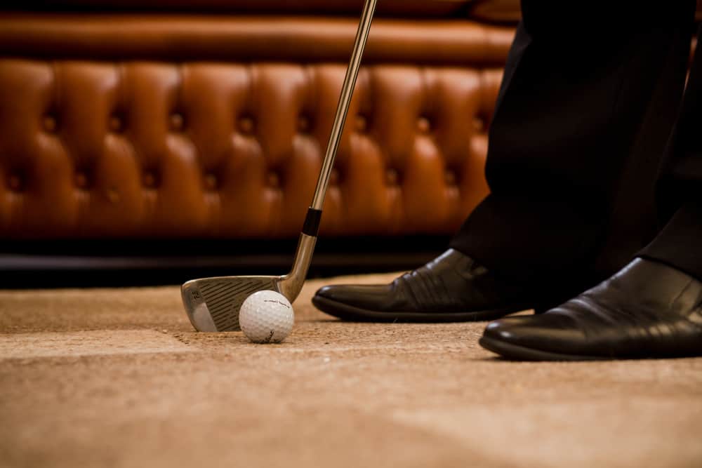 Man playing golf at office