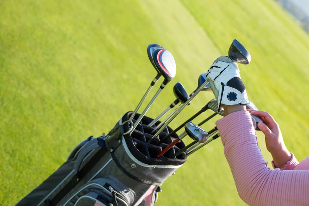 Professional golf player choosing the golf club