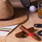 Siesta - cigar, straw hat,Scotch whiskey and golf driver on a wooden table