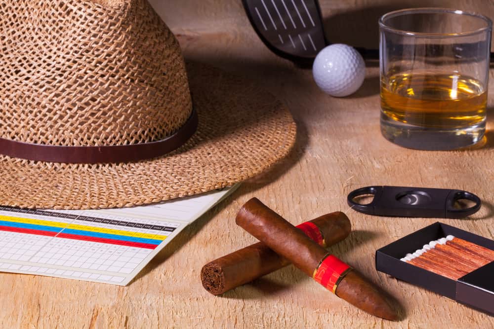 Siesta - cigar, straw hat,Scotch whiskey and golf driver on a wooden table