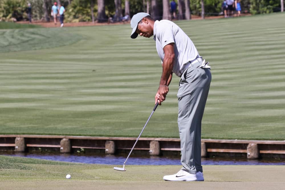 Tiger Woods putts the green