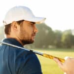 male golfer in hat holding golf club