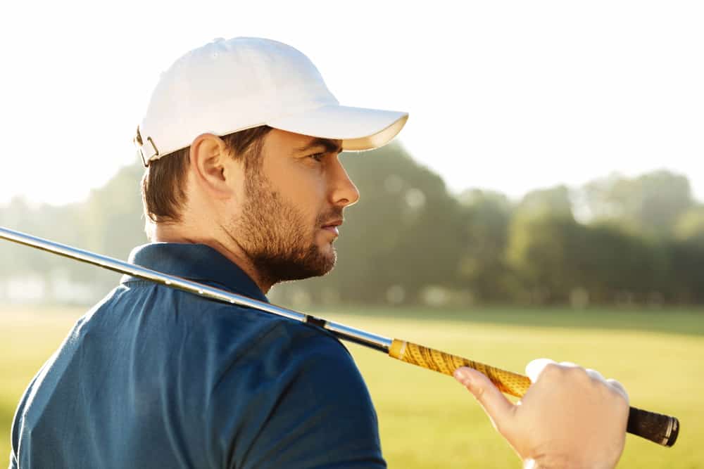 male golfer in hat holding golf club