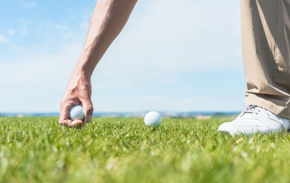 professional male player taking a golf ball