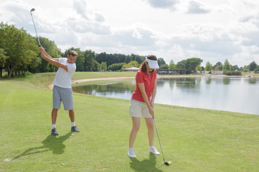 woman and man and golfers position