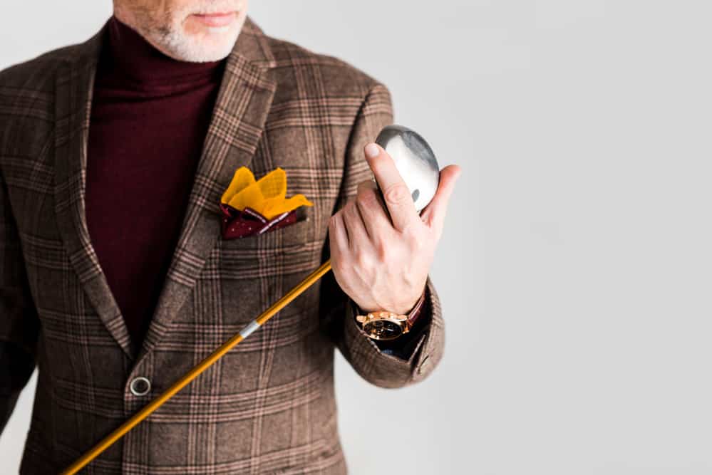 Cropped view of stylish mature man holding golf club