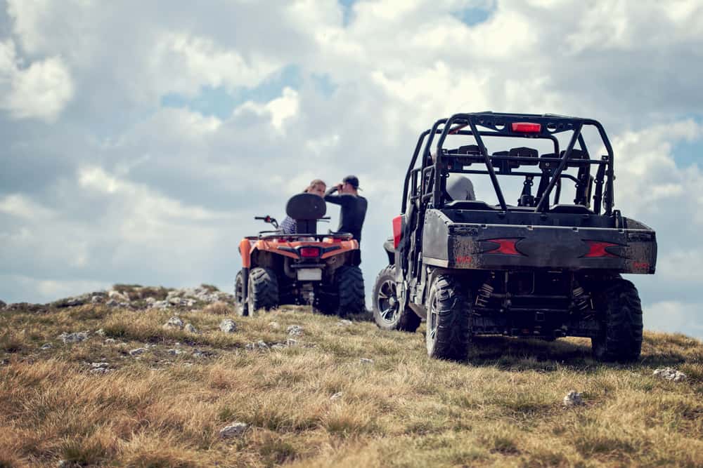 Friends driving off-road with quad bike or ATV and UTV