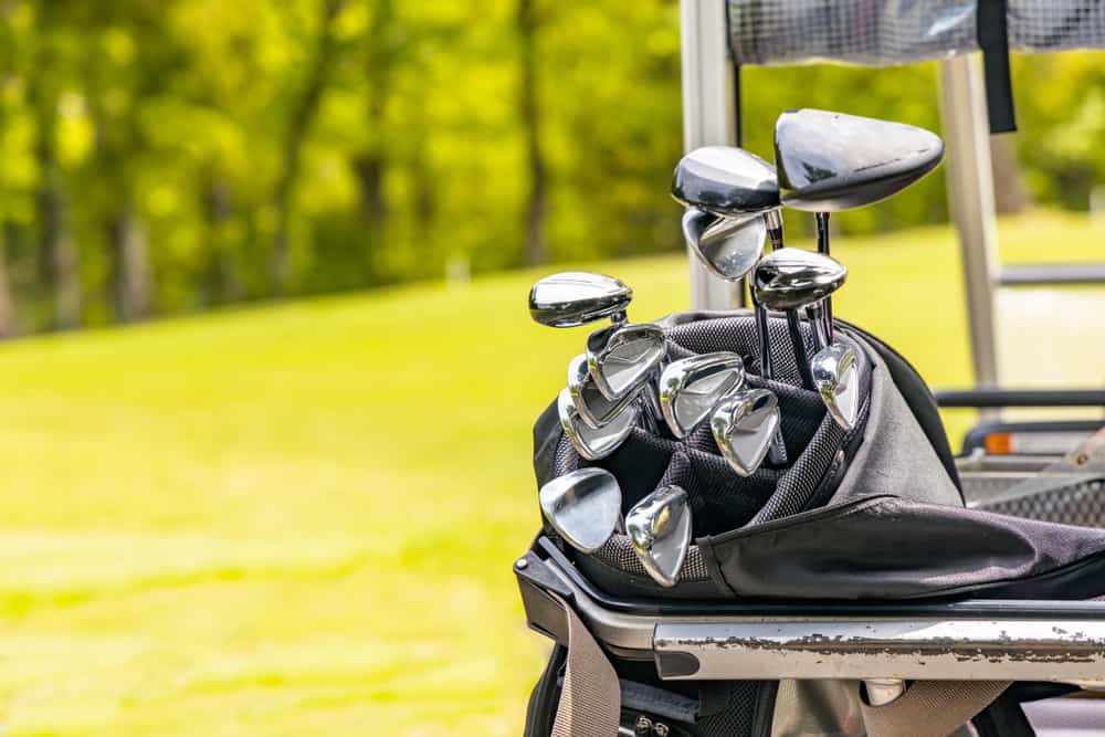 golf clubs on fresh green golf course