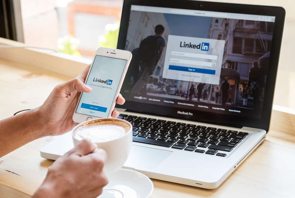  A women holds Apple iPhone 6S with LinkedIn application on the screen