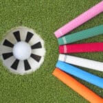 Colorful golf grips point to the golf hole with ball