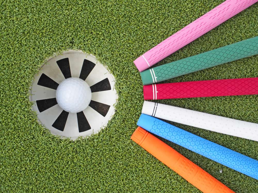 Colorful golf grips point to the golf hole with ball