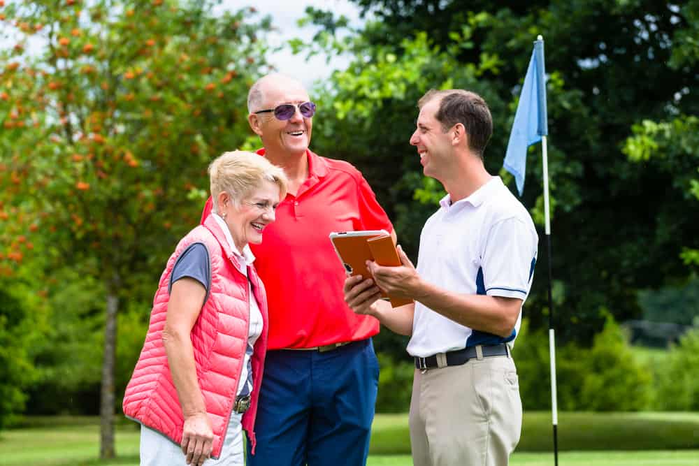 Golf pro with senior woman and man