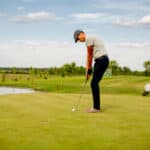 Handsome young man playing golf