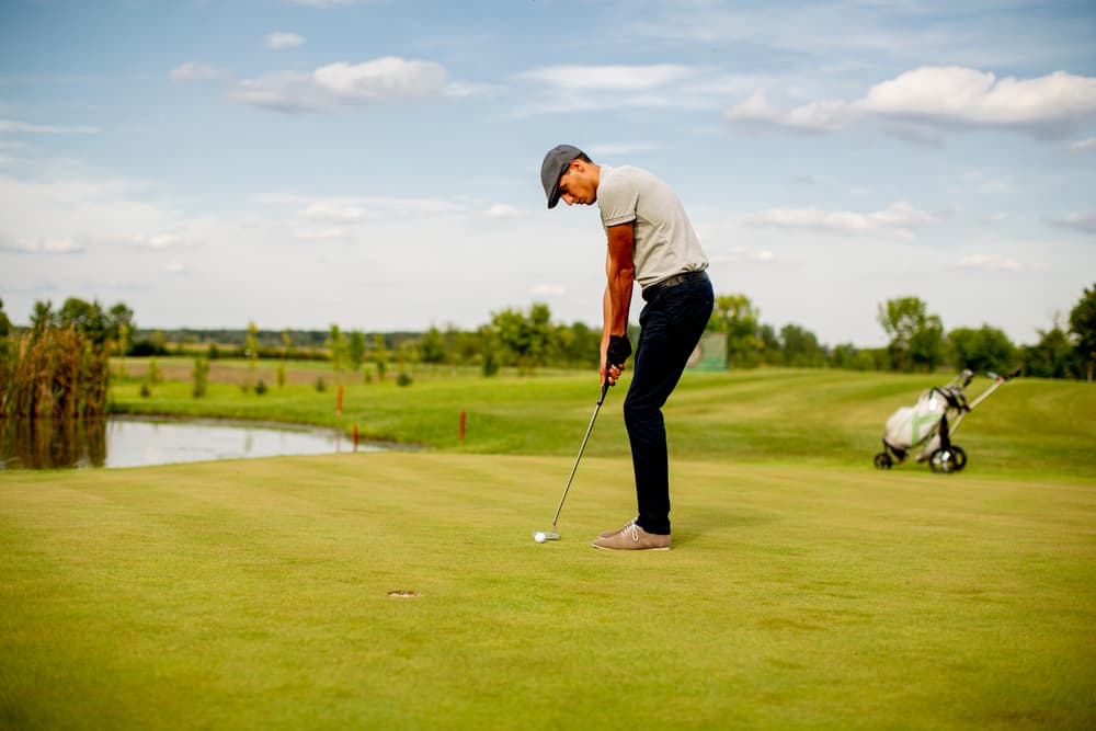 Handsome young man playing golf