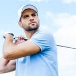 Low angle view of young golfer swinging his driver