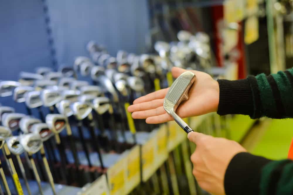 Person holding in hand club at a golf shop