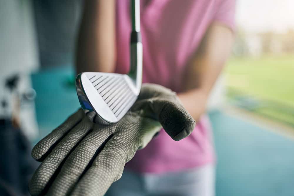 Player showing a golf wedge placed on her palm