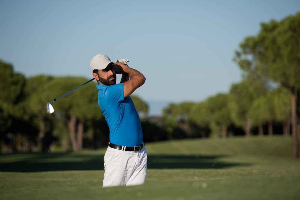 Pro golfer hitting a sand bunker shot