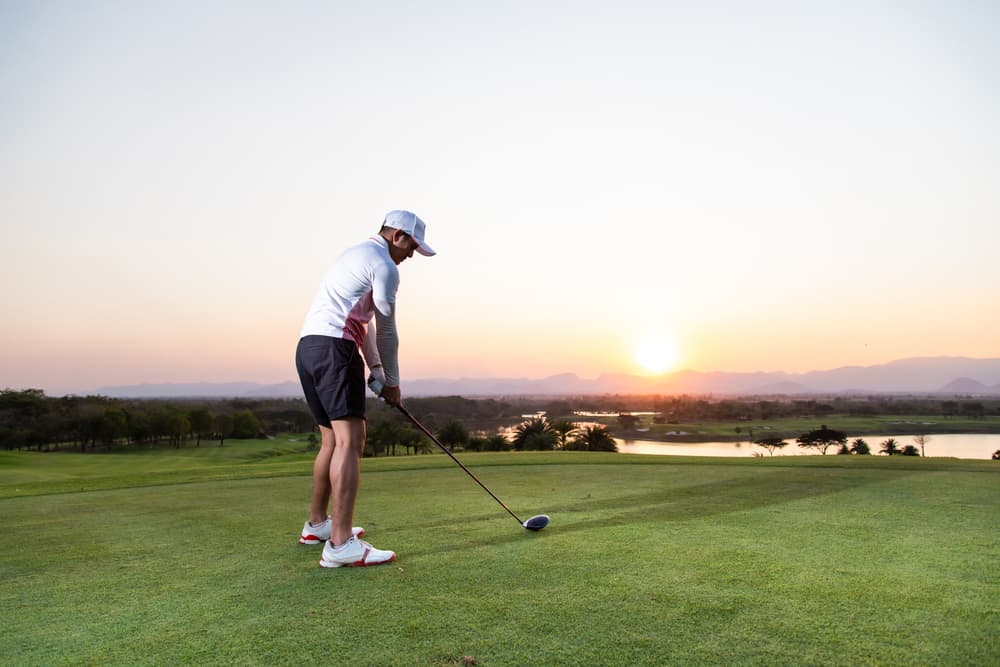 Pro golfer taking a shot at the sunset