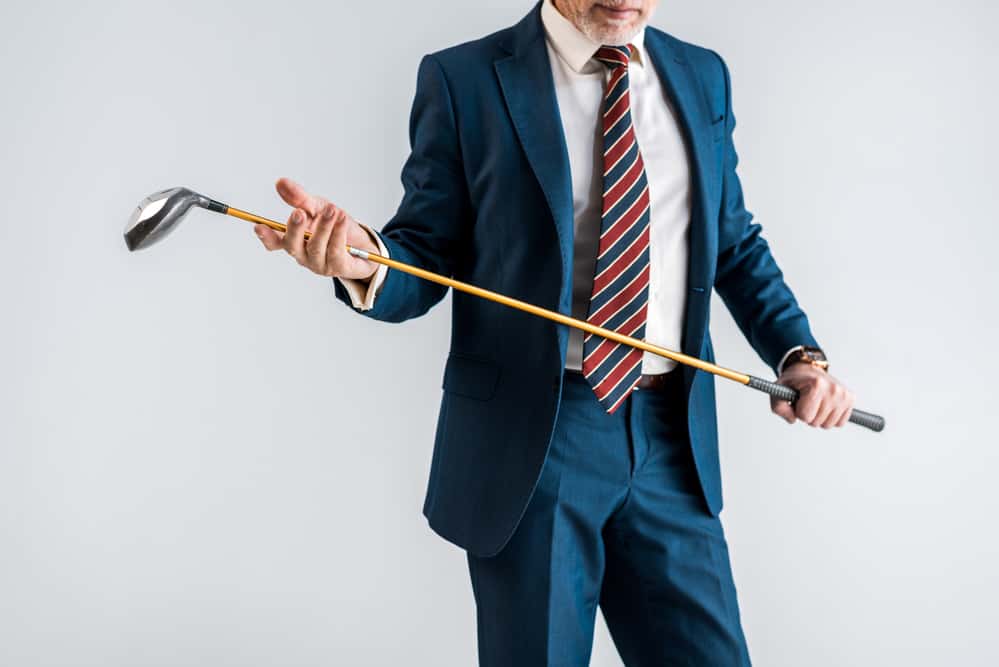 man in suit holding golf club